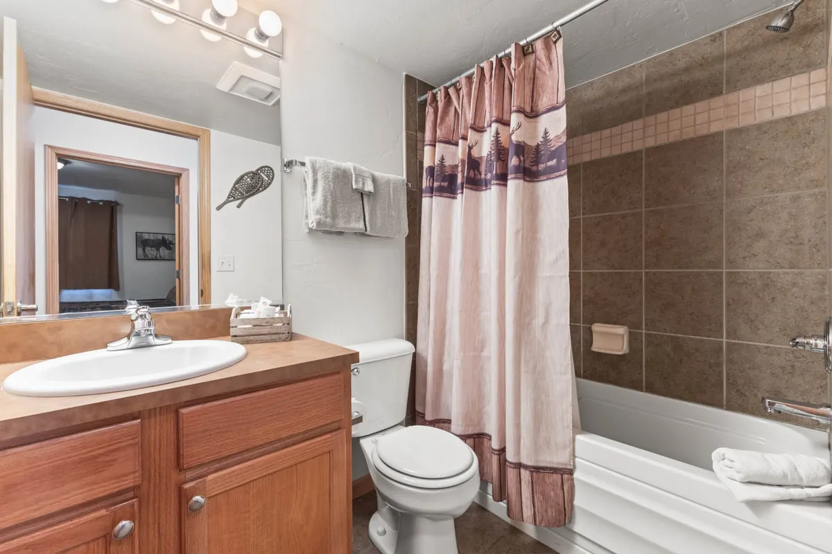 A bathroom with a vanity, large mirror, and a clean shower area, evoking a fresh and inviting atmosphere. The setup underscores daily routines and self-care, aligning with longer-term residential comfort.
